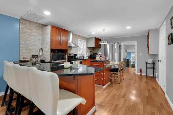 a kitchen with stainless steel appliances granite countertop a stove refrigerator sink and cabinets