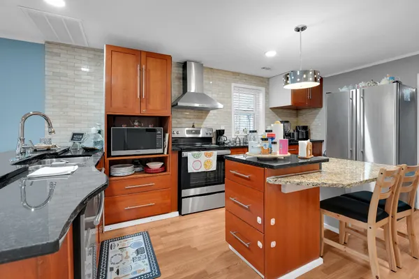 a large bed sitting in a bedroom next to a window and a chandelier