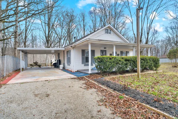 a view of a white house with large windows and wooden fence