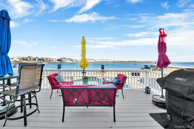 a roof deck with table and chairs a barbeque with wooden floor