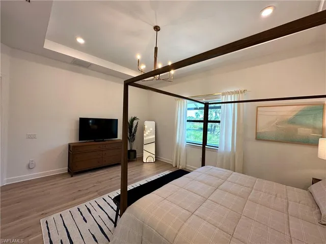 a bedroom with a bed window and a flat screen tv