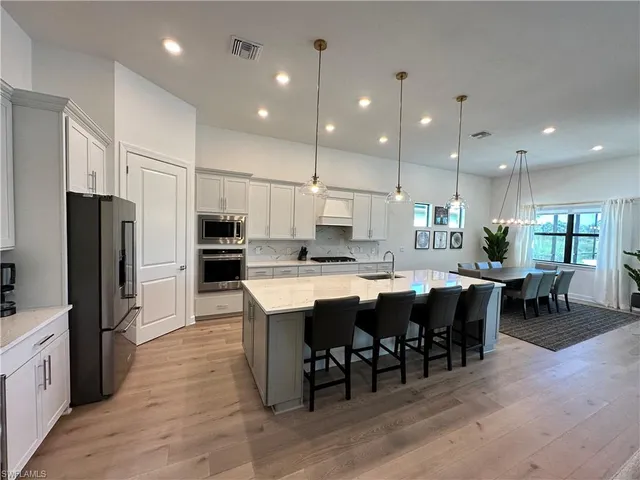 a large kitchen with a table and chairs