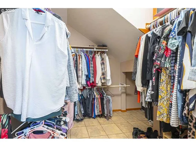 a view of walk in closet with clothes