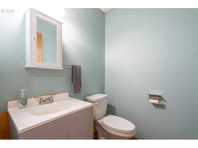 a bathroom with a toilet a sink and mirror