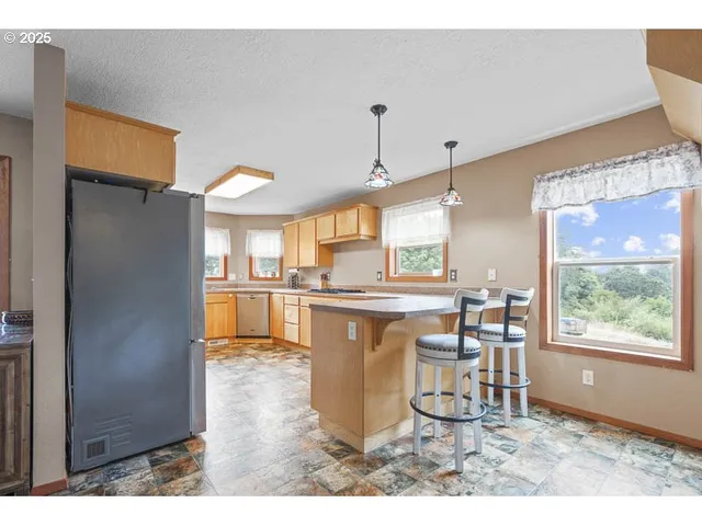 a kitchen with stainless steel appliances kitchen island granite countertop a refrigerator and microwave