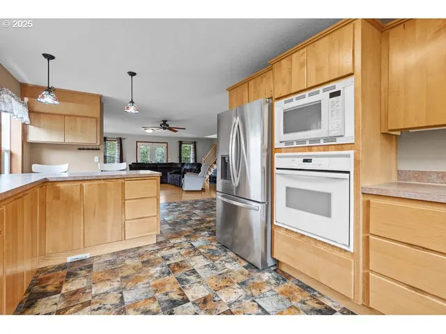 a kitchen with stainless steel appliances granite countertop a refrigerator a stove and a sink with cabinets