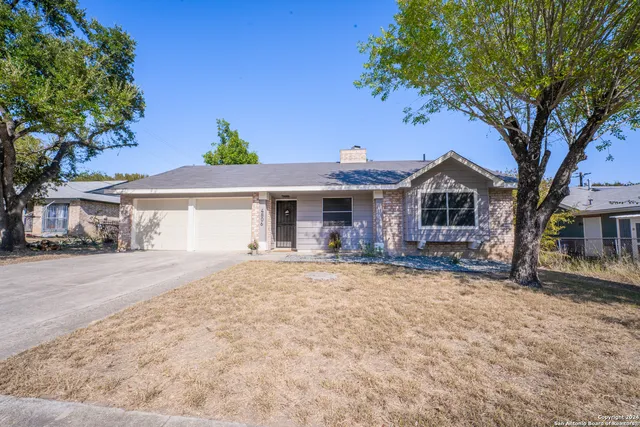 a front view of a house with a garden and yard