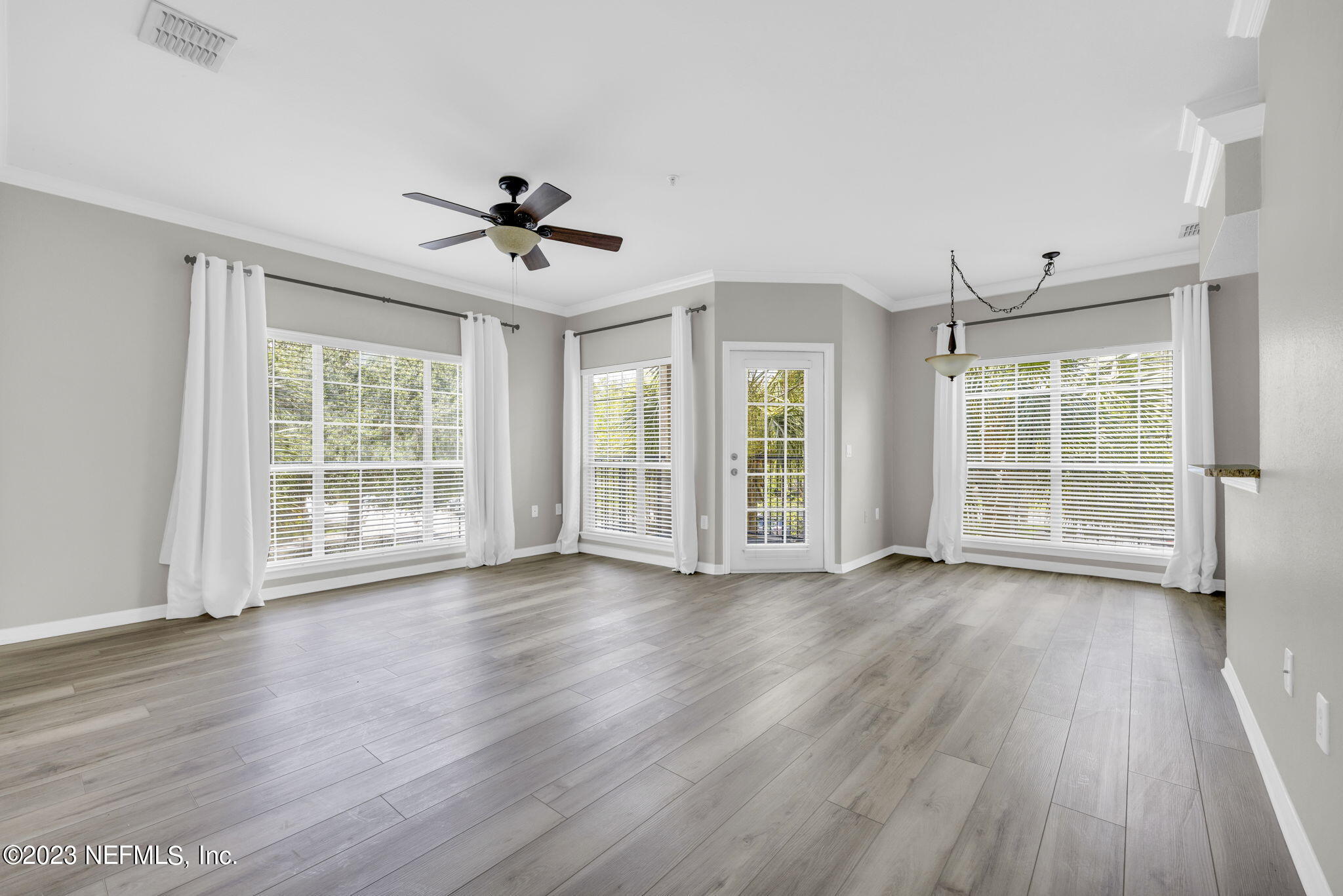 10961 Burnt Mill Road, Unit 427 Jacksonville, FL 32256 - Photo 1 of 50 a view of an empty room with wooden floor and a window