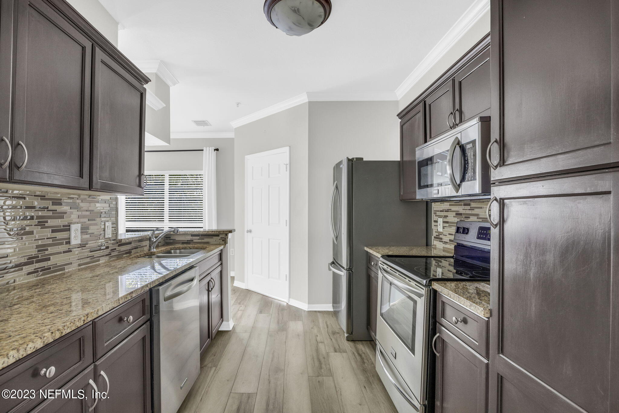 10961 Burnt Mill Road, Unit 427 Jacksonville, FL 32256 - Photo 14 of 50 a kitchen with stainless steel appliances granite countertop a refrigerator a stove a sink and a microwave