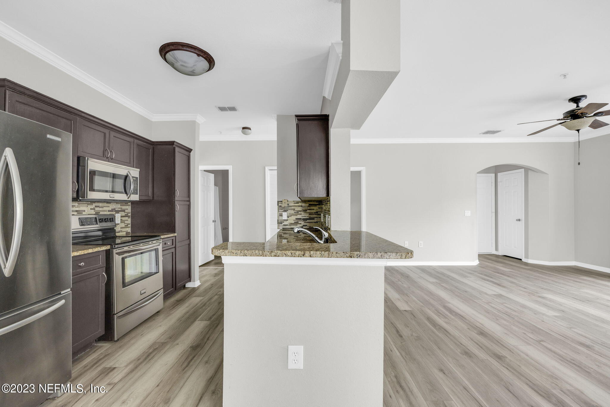 10961 Burnt Mill Road, Unit 427 Jacksonville, FL 32256 - Photo 15 of 50 a kitchen with stainless steel appliances a refrigerator a sink dishwasher a stove and white cabinets with wooden floor