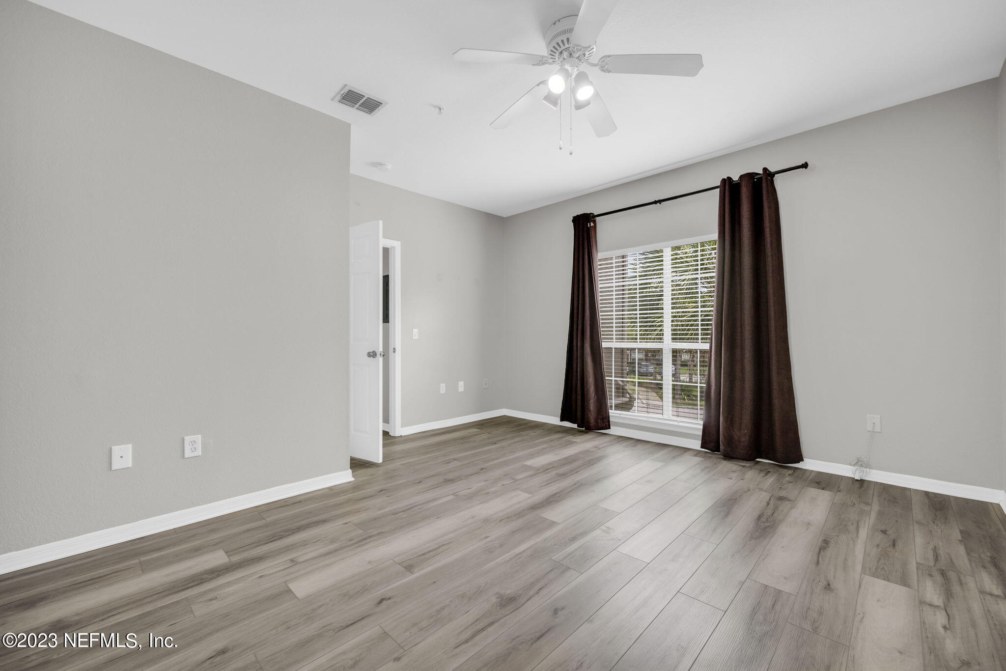 10961 Burnt Mill Road, Unit 427 Jacksonville, FL 32256 - Photo 17 of 50 wooden floor in an empty room with a window