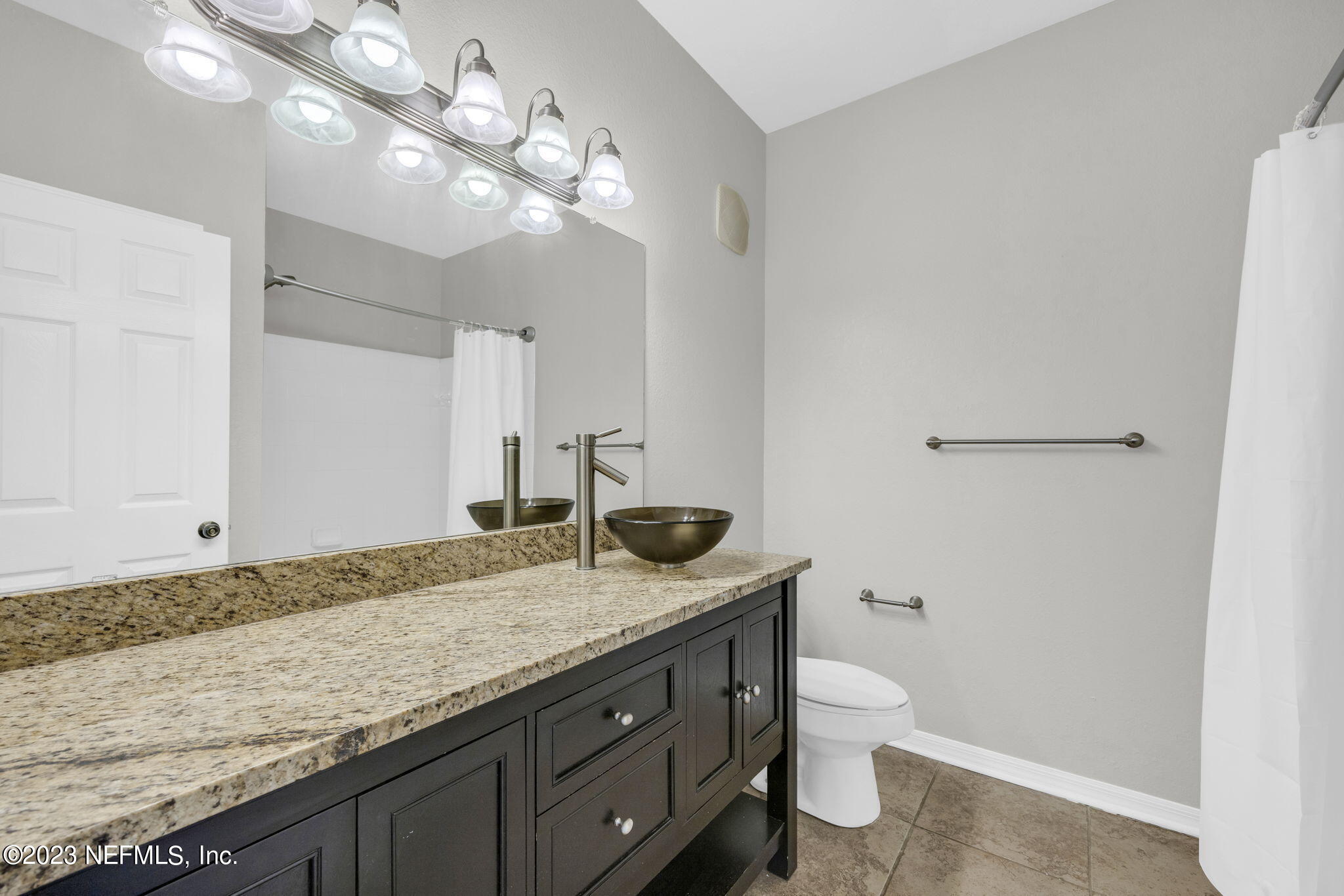 10961 Burnt Mill Road, Unit 427 Jacksonville, FL 32256 - Photo 19 of 50 a bathroom with a granite countertop sink a toilet and a mirror