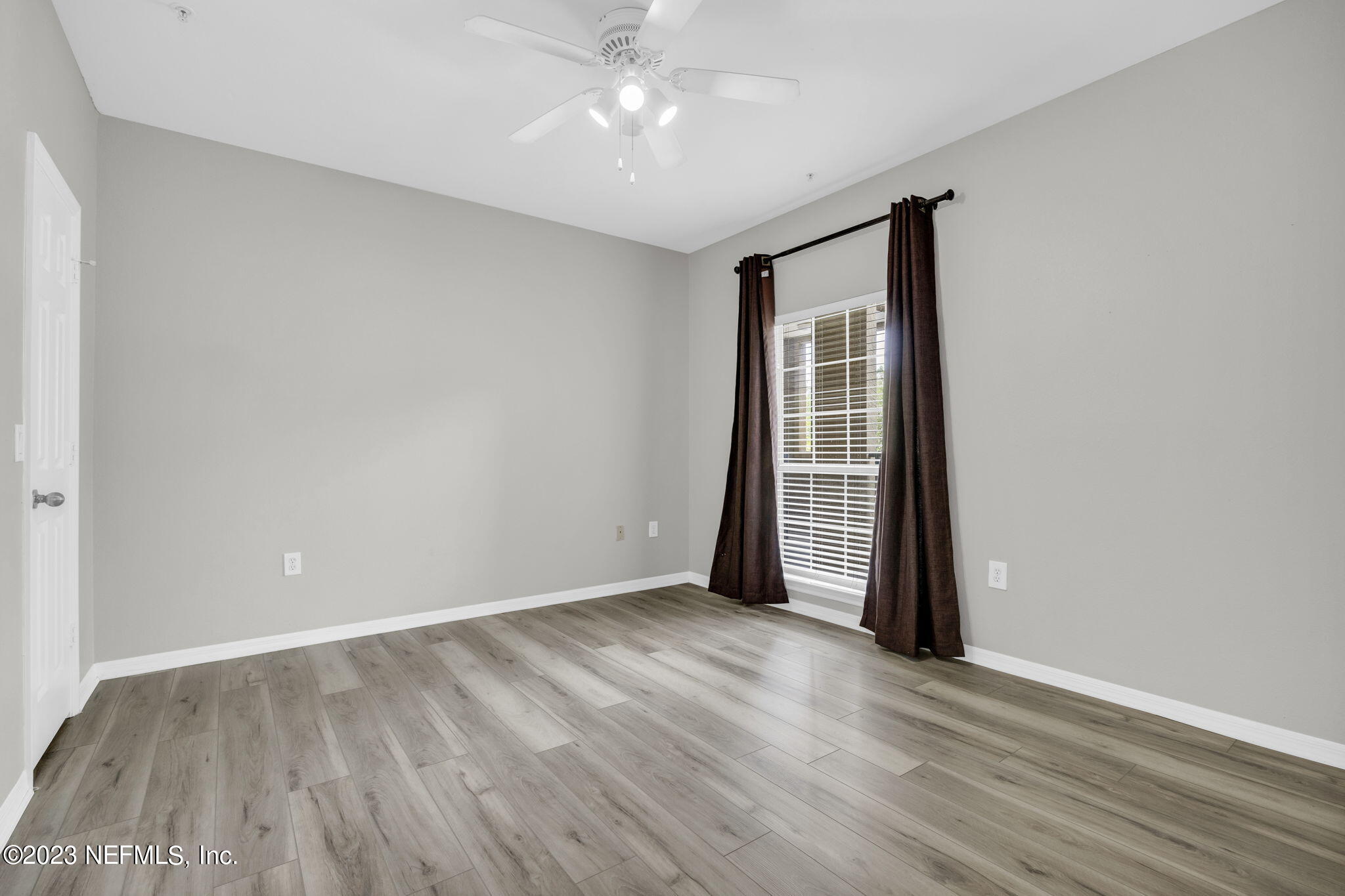 10961 Burnt Mill Road, Unit 427 Jacksonville, FL 32256 - Photo 22 of 50 wooden floor in an empty room with a window
