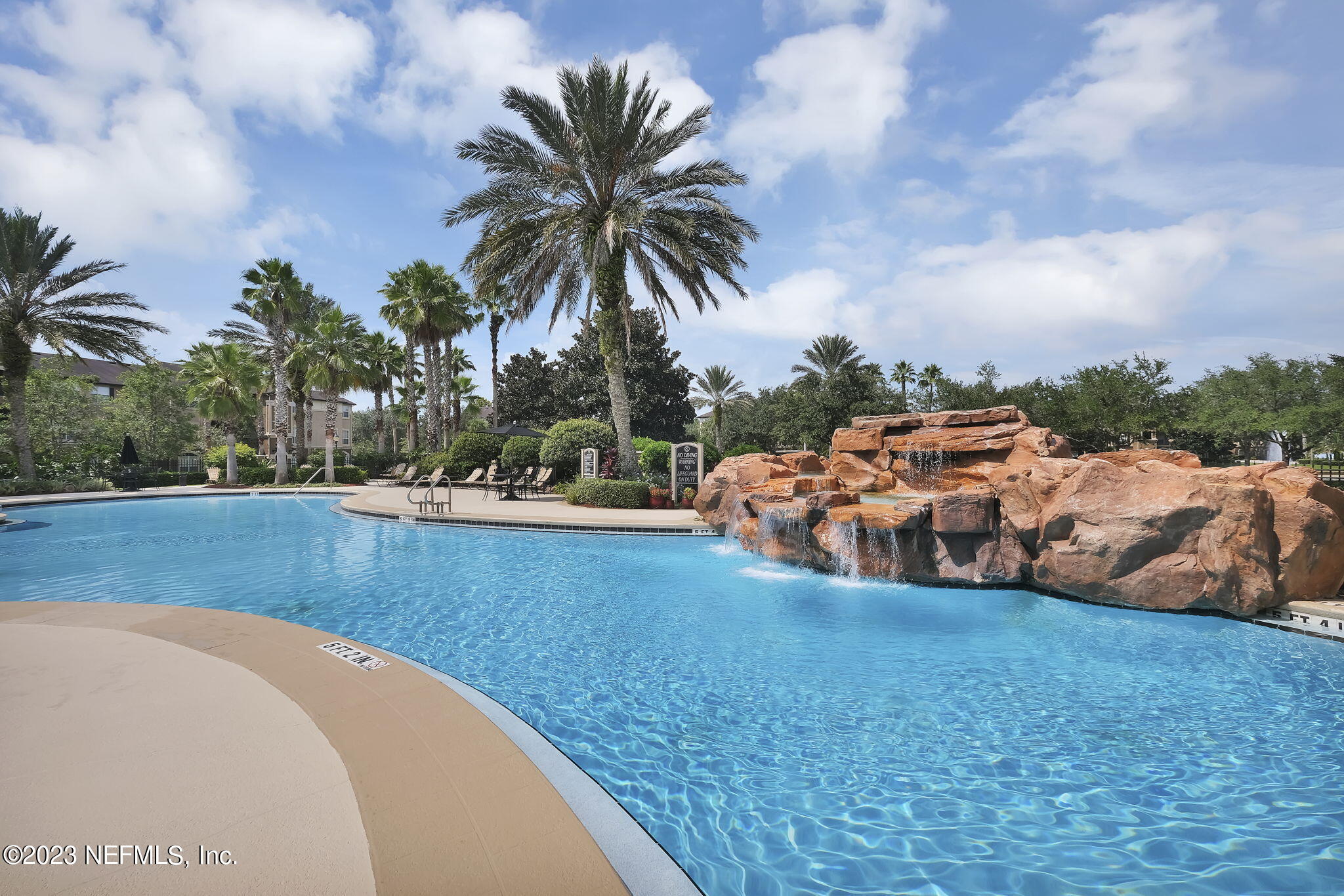 10961 Burnt Mill Road, Unit 427 Jacksonville, FL 32256 - Photo 37 of 50 a view of a swimming pool with an outdoor seating and a garden