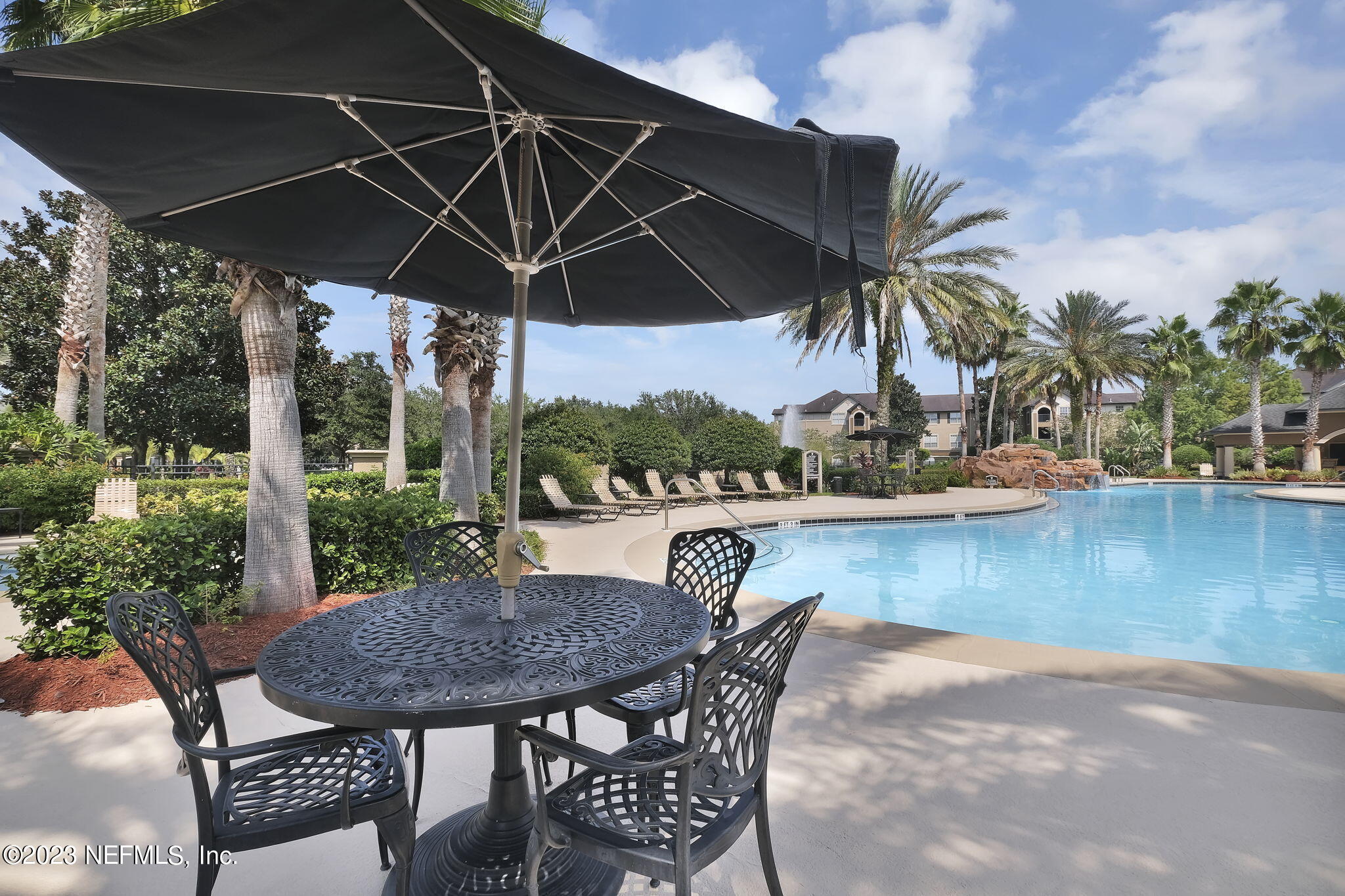 10961 Burnt Mill Road, Unit 427 Jacksonville, FL 32256 - Photo 39 of 50 a patio with wooden floor a yard a table and chairs