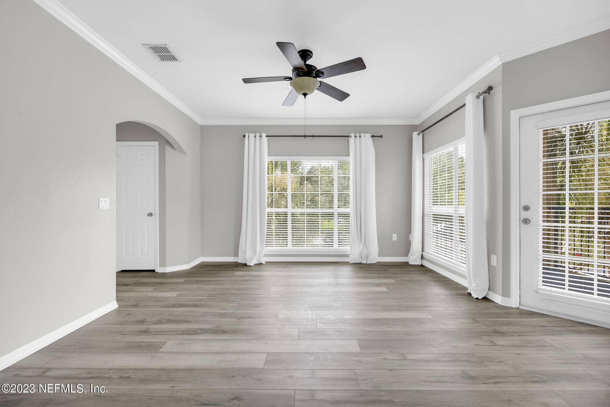 10961 Burnt Mill Road, Unit 427 Jacksonville, FL 32256 - Photo 6 of 50 a view of an empty room with wooden floor and a window