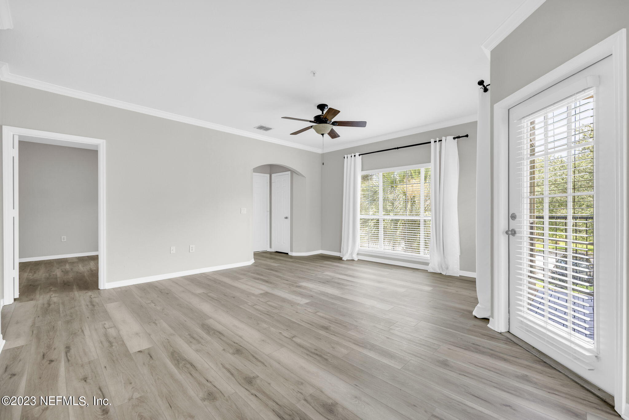 10961 Burnt Mill Road, Unit 427 Jacksonville, FL 32256 - Photo 7 of 50 a view of an empty room with wooden floor and a window