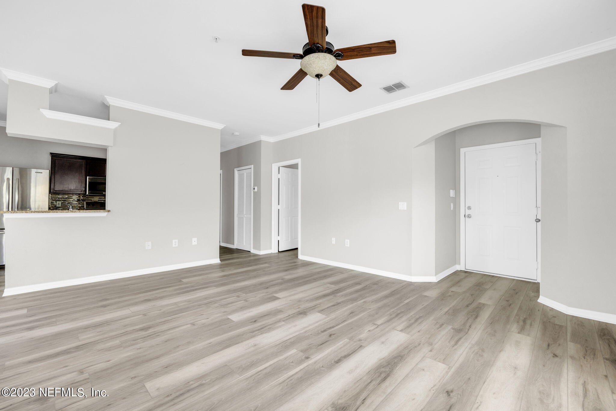 10961 Burnt Mill Road, Unit 427 Jacksonville, FL 32256 - Photo 10 of 50 a view of an empty room with wooden floor and a ceiling fan