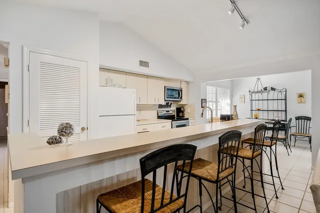 a kitchen with a table chairs refrigerator and cabinets
