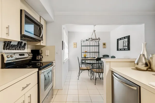 a kitchen with granite countertop a stove top oven microwave and cabinets