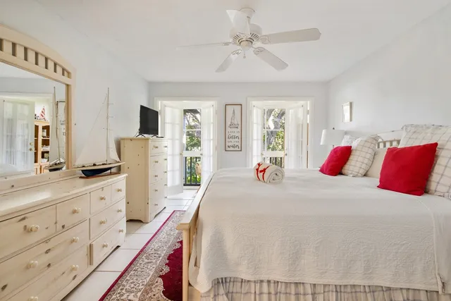 a spacious bedroom with a bed a dresser and windows