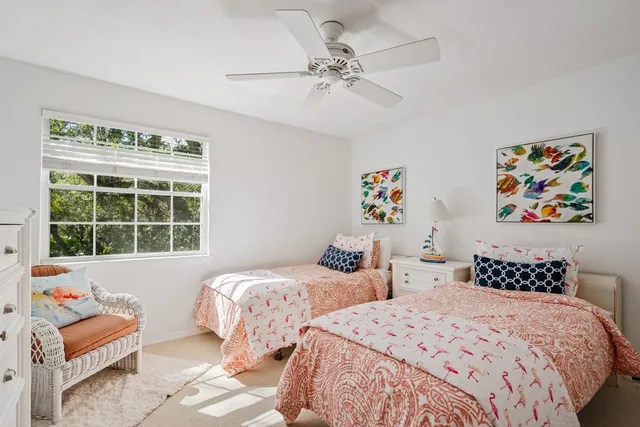 a bedroom with two beds and a window