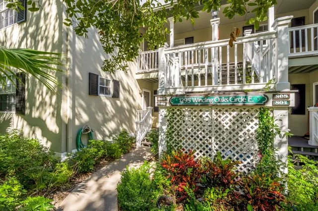 a view of a brick house with a flower garden