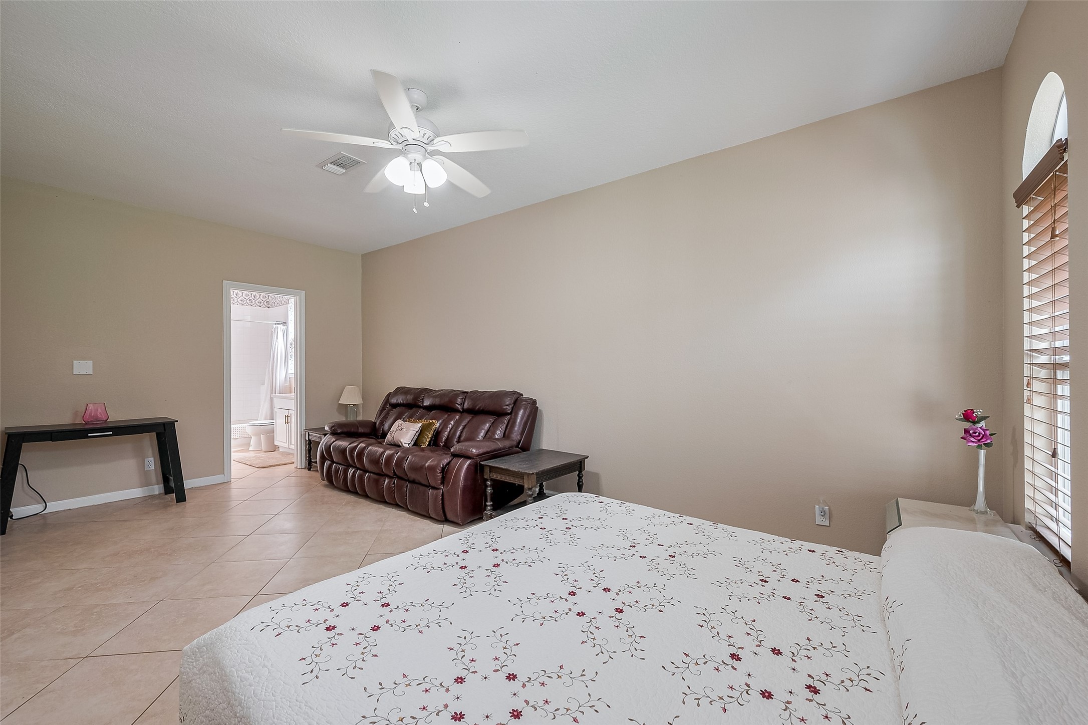 2499 Southline Road Conroe, TX 77384 - Photo 30 of 49 Spacious primary bedroom with tile flooring, ceiling fan, and private en-suite access.
