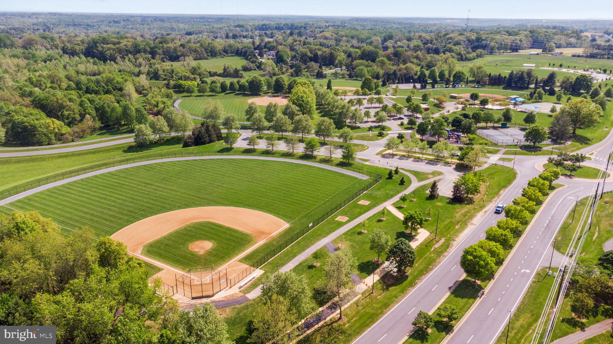 14421 Ashleigh Greene Road Boyds, MD 20841 - Photo 81 of 95 an aerial view of a tennis ground and a cars park side of the road