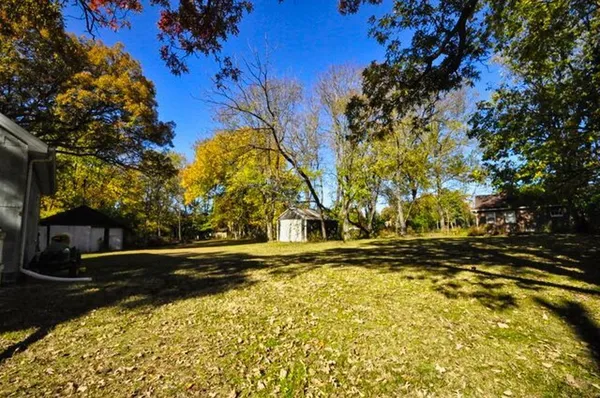 a backyard of a house with lots of green space and trees all around