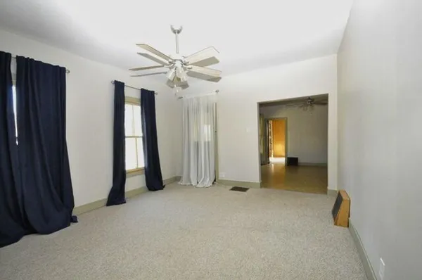 an empty room with closet and a ceiling fan