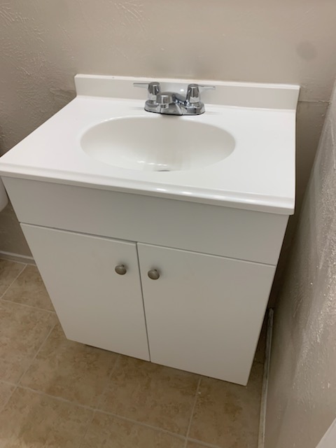 2701 Poplar Circle, Unit G Bryan, TX 77801 - Photo 7 of 8 Bathroom with vanity, a textured wall, and light tile patterned flooring