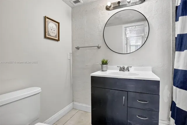 a bathroom with a sink mirror and toilet