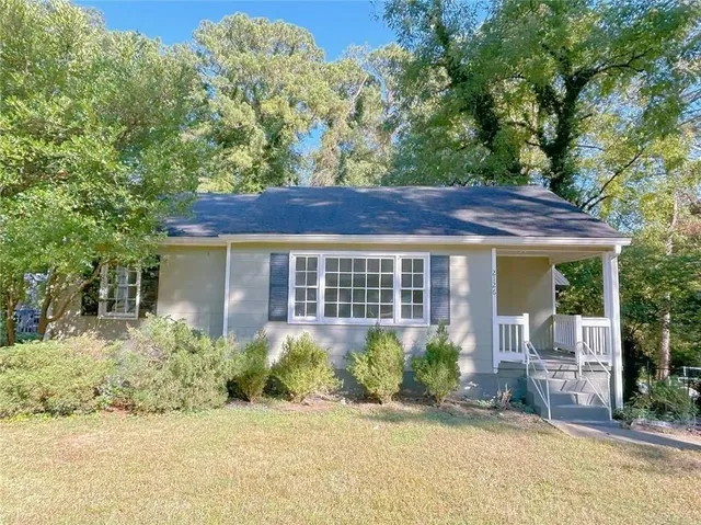 a view of a house with backyard and sitting area