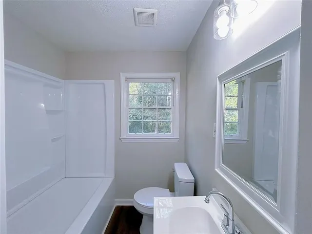 a bathroom with a toilet and a shower