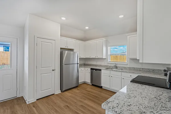 a kitchen with a refrigerator sink and cabinets