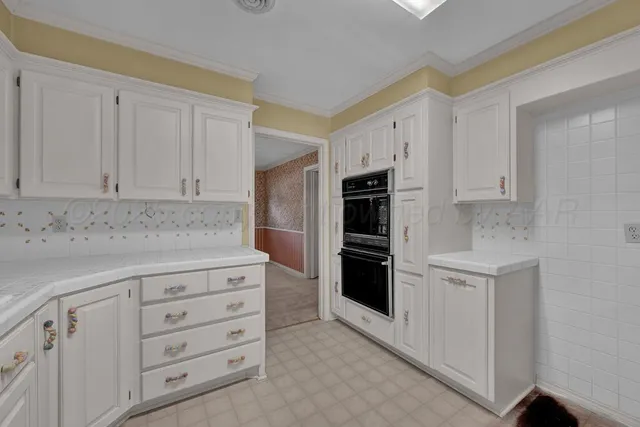a kitchen with granite countertop white cabinets and refrigerator