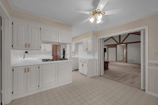 a kitchen with white cabinets and white appliances