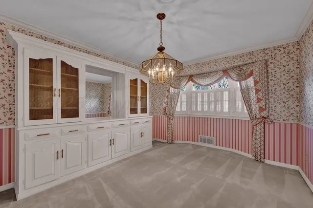 a spacious bedroom with a large bed and a chandelier