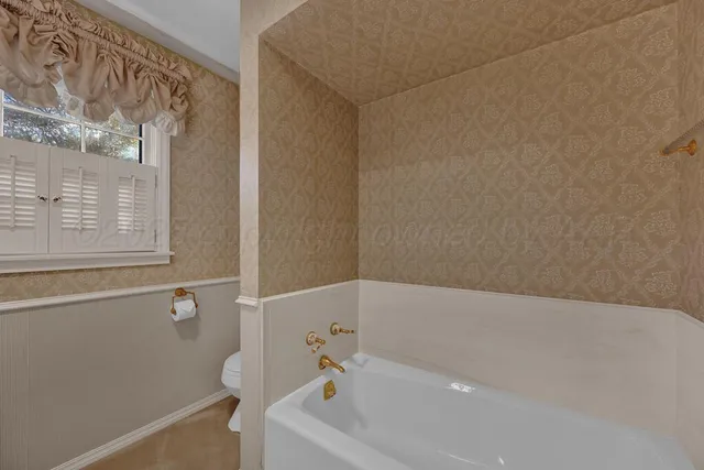 a spacious bathroom with a toilet sink and mirror