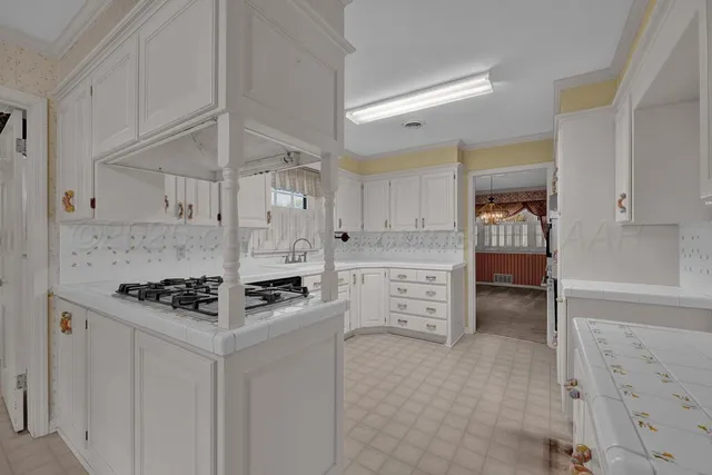 a kitchen with stainless steel appliances a stove a sink and white cabinets