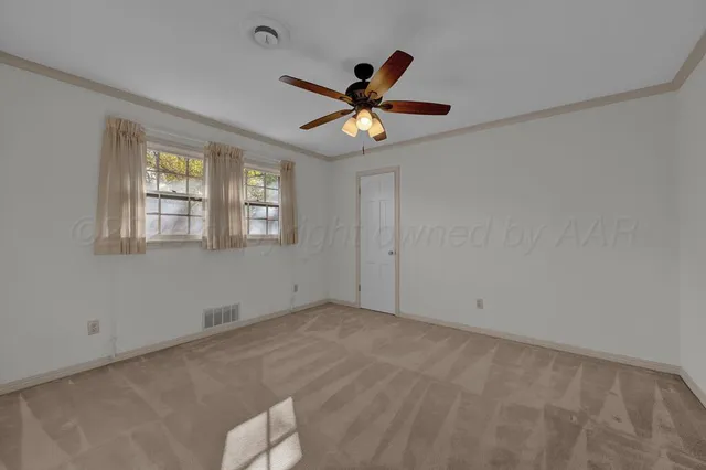 a view of an empty room with window and a kitchen