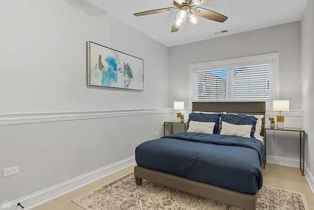 a bedroom with a large bed and a chandelier