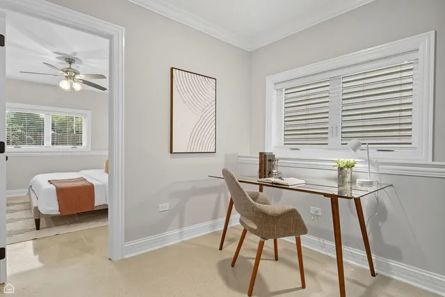 a view of a workspace with furniture and a window
