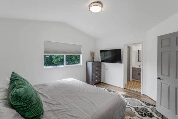 a bedroom with a bed and a flat screen tv