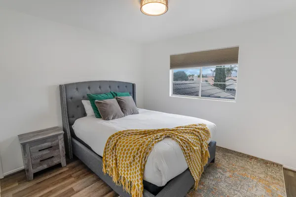 a bedroom with a bed and painting on the wall