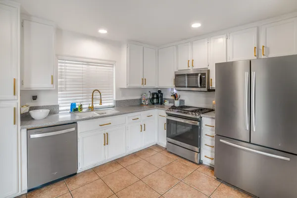 a kitchen with granite countertop stainless steel appliances and white cabinets