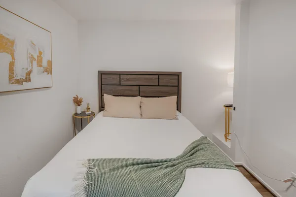 a bedroom with a bed and painting on the wall