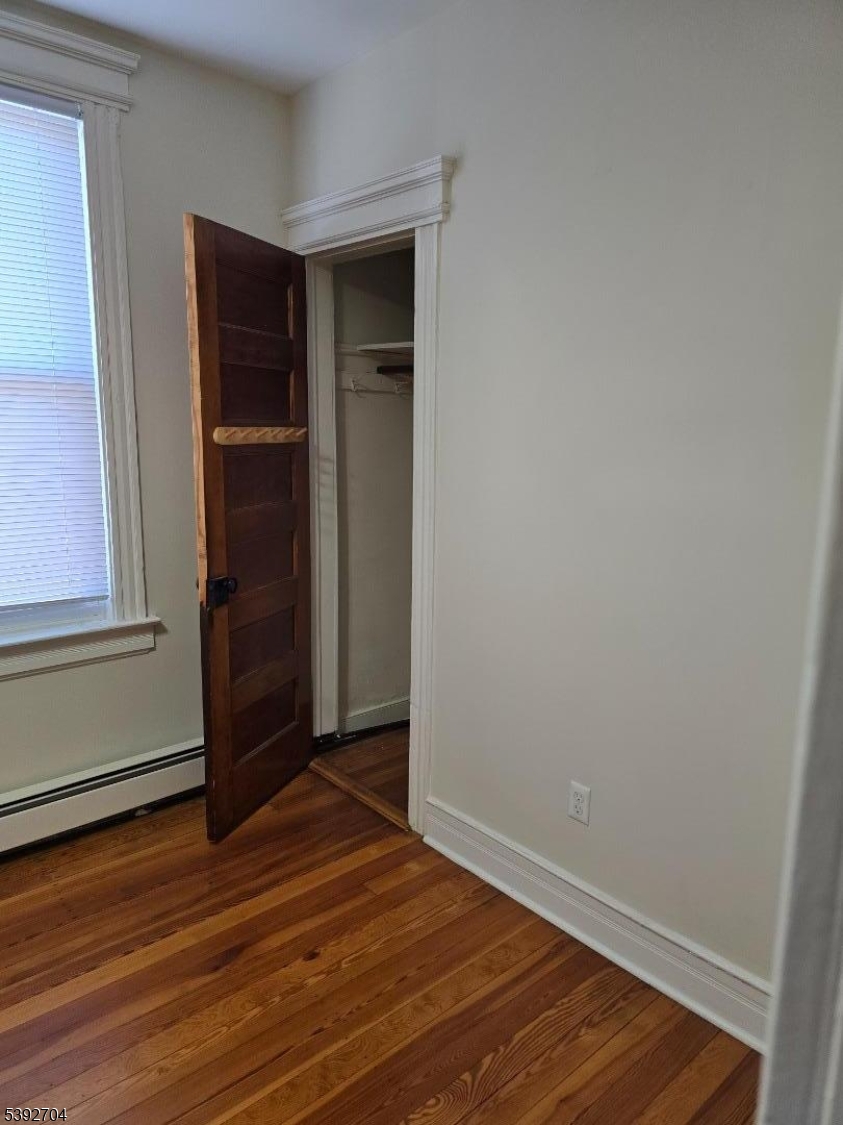 49 Barbara Street Newark, NJ 07105 - Photo 5 of 6 an empty room with wooden floor and closet