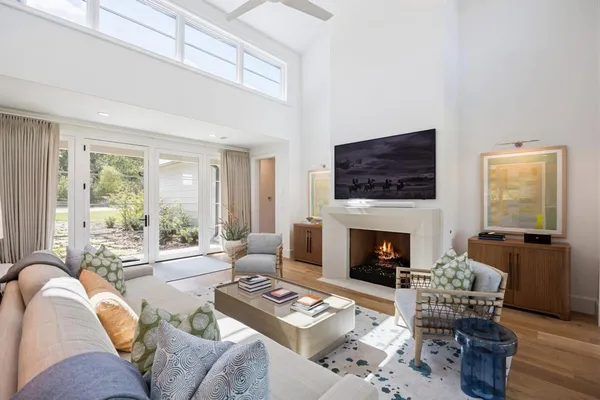 a living room with furniture fireplace and a large window